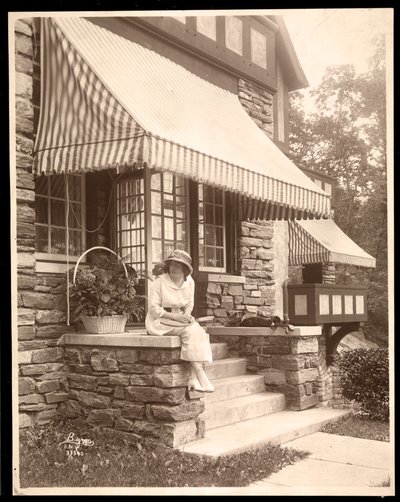 Een vrouw zittend bij de ingang van een huis, 1915 door Byron Company